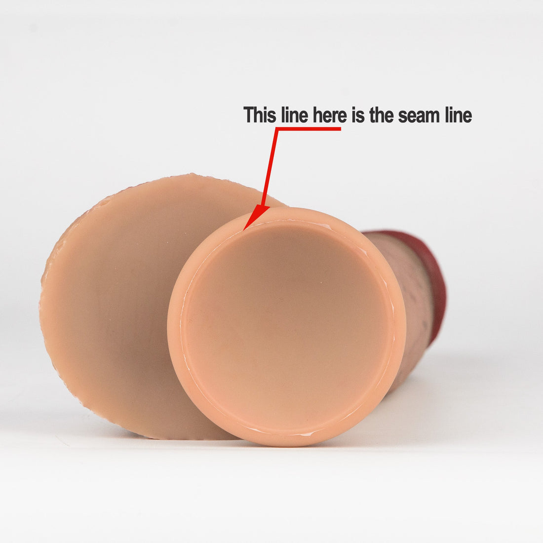 Close-up of silicone dildo suction cup base with red arrow pointing to the mold seam line — RealTouch Lab seam line material test guide