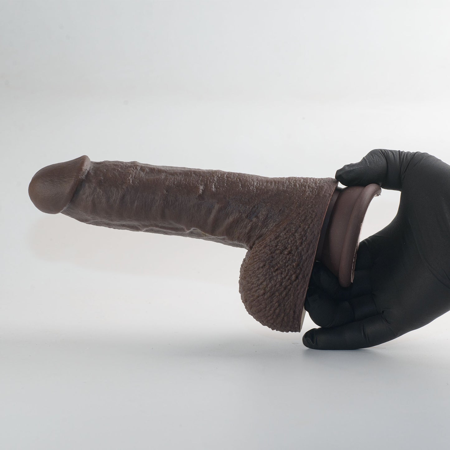 Stage 03 Giganotosaurus dual-density silicone dildo - hand in black nitrile glove holding product horizontally to demonstrate size and weight - body-safe platinum-cured | RealTouch Lab
