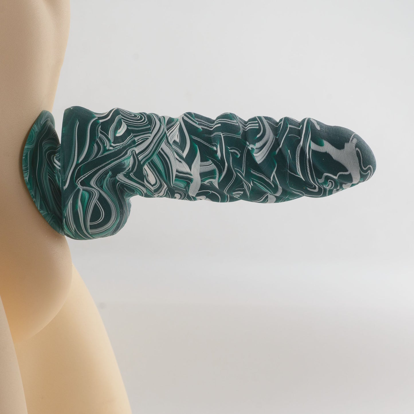 Griffin Fantasy Collection silicone dildo - suction cup mounted on plastic mannequin body demonstrating hands-free use, side view showing product extending horizontally with teal and white marble swirl colorway, dense twisted ridge texture along full shaft length and fantasy rounded tip - body-safe platinum-cured single-density silicone | RealTouch Lab
