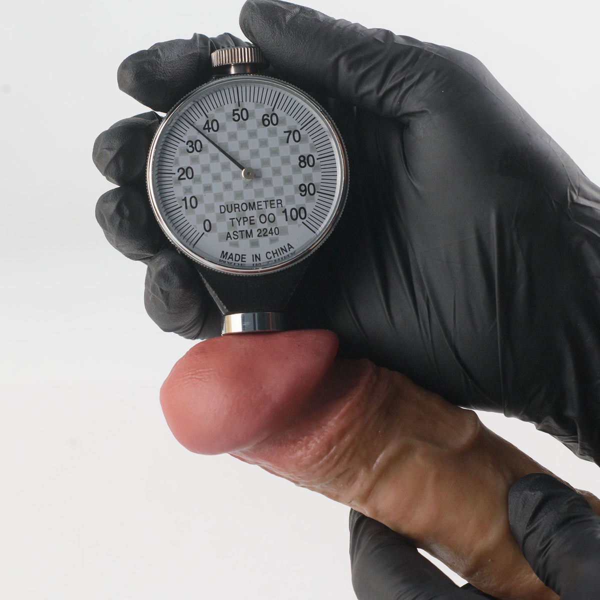 Stage 04 Velociraptor hand-painted silicone dildo - Shore 00 durometer Type OO ASTM 2240 hardness test on glans surface showing approximately 35 Shore 00 softness rating - scientifically verified ultra-soft outer layer comparable to human tissue - dual-density body-safe platinum-cured | RealTouch Lab
