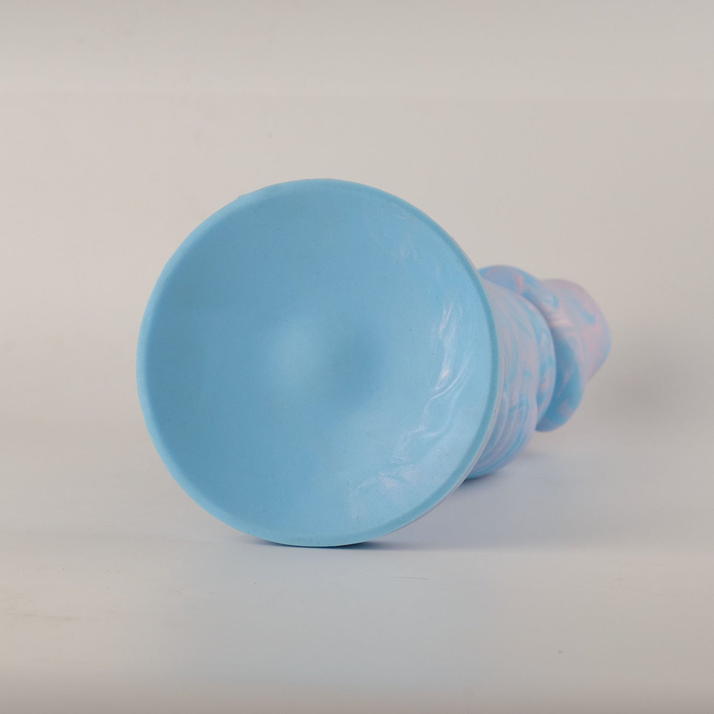 Leviathan Fantasy Collection silicone dildo - bottom view lying flat showing large sky blue suction cup cavity with smooth deep concave surface and clean circular rim - 3.94in/10cm diameter suction cup for strong hands-free surface adhesion - body-safe platinum-cured single-density silicone | RealTouch Lab
